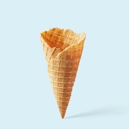 wafer ice cream cone on a blue background. minimalistic concept.