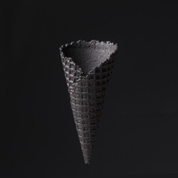 black cone for ice cream on black background. creative, minimalistic concept
