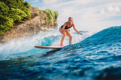 attractive surf woman on surfboard. woman in ocean during surfing.