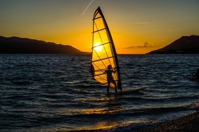 windsurfing at sunset. perfect activity for summer.