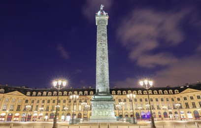 vendome column with statue of napoleon bonaparte, on the place vendome at night, in france. vendome column has 425 spiraling bas-relief bronze plates were made out of cannon.