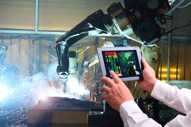 engineer hand using tablet with machine real time monitoring system software.digital manufacturing operation. automation robot arm machine in smart factory automotive industrial , industry 4.0 concept