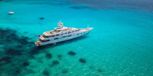 big luxury yacht anchoring in shallow water, aerial view. active life style, water transportation and marine sport.