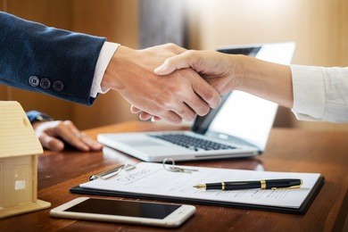 house developers agent or financial advisor and customers shaking hands after signing document making deal as successful agreement, contract with a firm