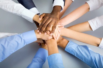international  business team showing unity with their hands together