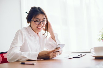 shot of an attractive businesswoman working on smart phone in her workstation.