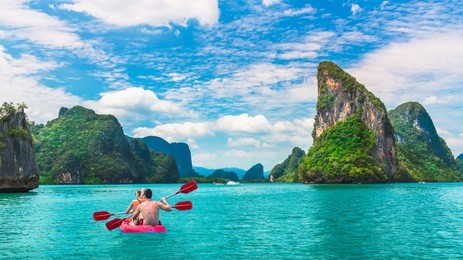 beautiful nature landscape of island with active outdoor couple traveler kayaking phang-nga bay,  water travel adventure phuket thailand,  tourism destination place asia, summer holiday vacation trip
