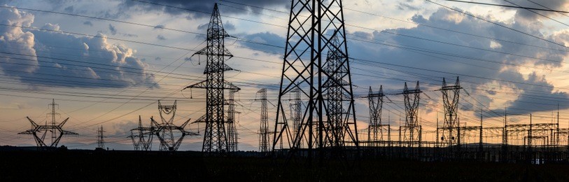 electricity transmission pylon silhouetted against sunset sky. high voltage electric tower line.

