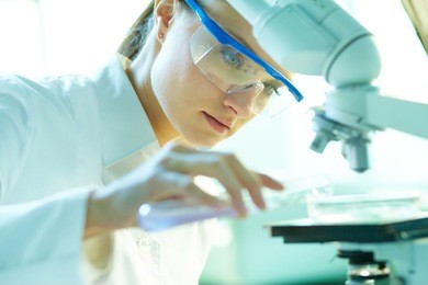 serious female chemist working in laboratory