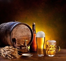 beer barrel with beer glasses on a wooden table. the dark brown background.