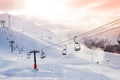 winter mountains panorama with ski slopes and ski lifts on a cloudy day