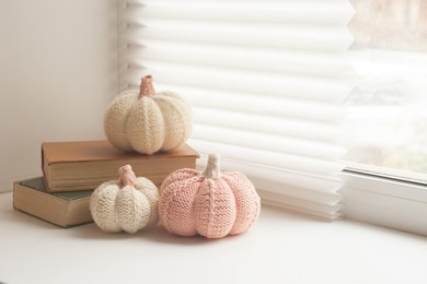 cosy and soft winter, autumn, fall background, knitted decor and books on an windowsill. christmas, thanksgiving holidays at home, calmness closeup, weekend concept
