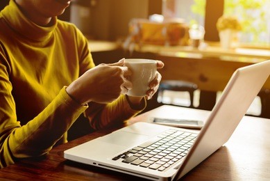asian working women hand holding white cup of coffee in the office at the winter weather, relax and lifestyle concept.