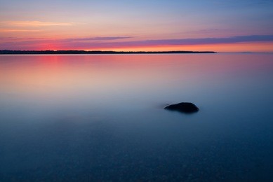 long exposure of sea with lonely rock. scenic sunset over the baltic sea. poland
