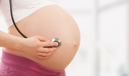 belly of pregnant woman and stethoscope