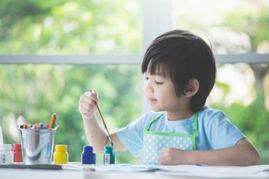 cute asian boy painting a picture