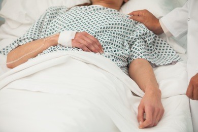 old sick lady lying in hospital bed