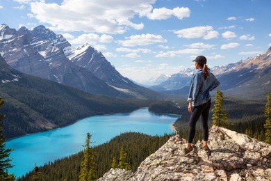young girl enjoying the beautiful canadian rockies landscape view during a vibrant sunny summer day. taken in peyto lake, banff national park, alberta, canada.