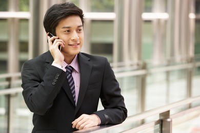 chinese businessman outside office on mobile phone