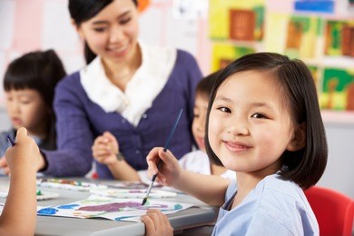 female pupil enjoying art class in chinese school classroom