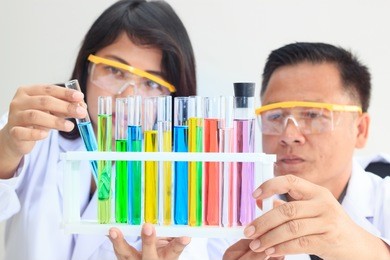 young female and male scientist team examining with color test tube in laboratory for science research. concept science and medical image.