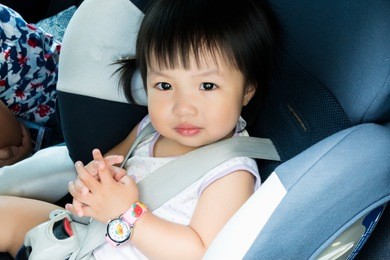 portrait of cute toddler girl sitting in car seat. child transportation safety