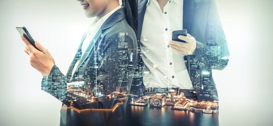 young business people using mobile phone with modern city buildings background. future telecommunication technology and internet of things ( iot ) concept.