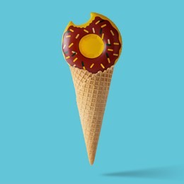 inflatable donut pool toy with ice cream cone on pastel blue background. minimal summer concept.