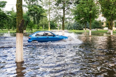 the car driving on a flooded road during a flood caused by heavy rain.