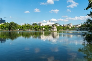 hoan kiem lake or sword lake, ho guom in hanoi, vietnam with turtle tower, on clear day with blue sky and white clouds