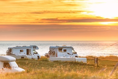 recreational vehicle at sunset in norway, europe. meadow and coast with cloudy sky and sun. travel by rv. nordic country, europe, scandinavia.