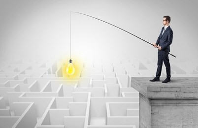 young businessman fishing new idea concept on the top of a building from a maze