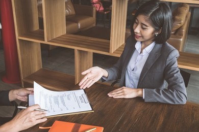 job interview in office, employer reviewing good cv of prepared skilled applicant, recruiter considering application, hr manager making hiring decision