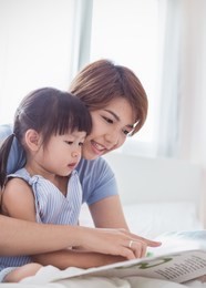 portrait of beautiful asian mother hold story book reading teaching daughter little girl in bedroom. home school learn from teacher, education happy family love together mother’s day holiday concept.