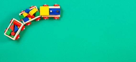 wooden toy train with colorful blocks on green background