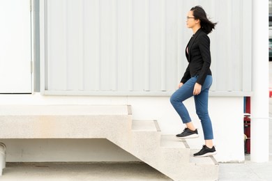young businesswoman walking up the stairs with success, copy space.