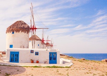windmills on a hill near the sea on the island of mykonos