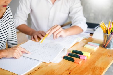 woman learn and teach tutor concept education  helping each other sitting in a table at class room