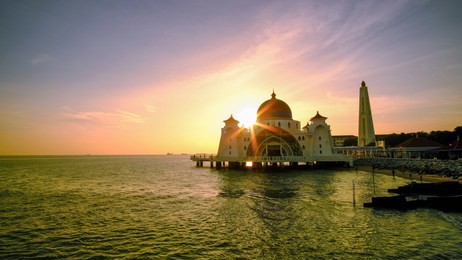 breathtaking sunset at straits mosque of malacca with starburst, malacca, malaysia.