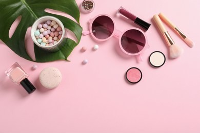 flat lay composition with products for decorative makeup on pastel pink background