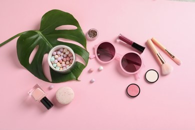 flat lay composition with products for decorative makeup on pastel pink background
