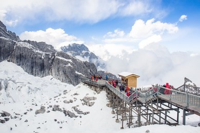 tourists travel to see wonderful view of jade dragon snow mountain in yunnan, china.