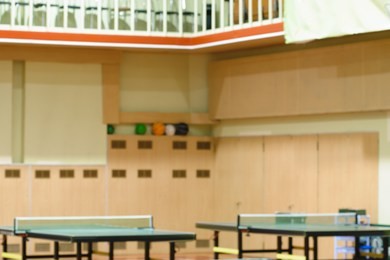 naturally blurred interior of modern gym with tables for ping-pong