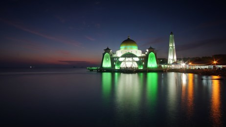 magnificent scenery of sunset with rays of light at golden hour over the majestic mosque, malacca straits mosque (masjid selat). located in malacca town, malaysia.