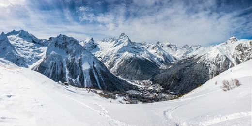 panoramic view of the ski slope with the mountains belalakaya, sofrudzhu and sulakhat on the horizon in winter day. dombai ski resort, western caucasus, karachai-cherkess, russia.