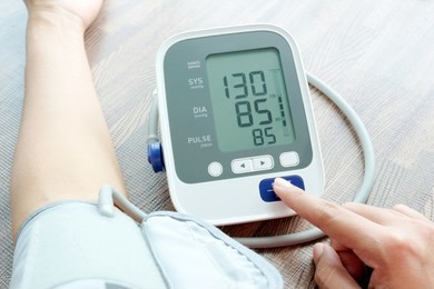 woman check blood pressure monitor and heart rate monitor with digital pressure gauge. health care and  medical concept