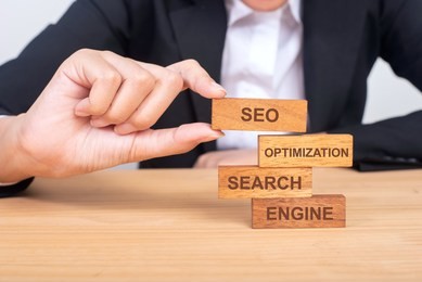 business hand building seo concept with wooden blocks on wood, search, engine, optimization, seo.