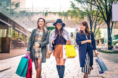 three women doing shopping outdoors - best friends meeting while shopping in tokyo