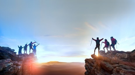 businessman and women group hike on the peak of  rocks mountain at sunset, success, winner, leader and teamwork concept .