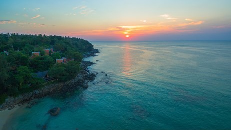 aerial view the sun going down to holison at karon beach phuket two jet boats sail in karon sea during sunset 